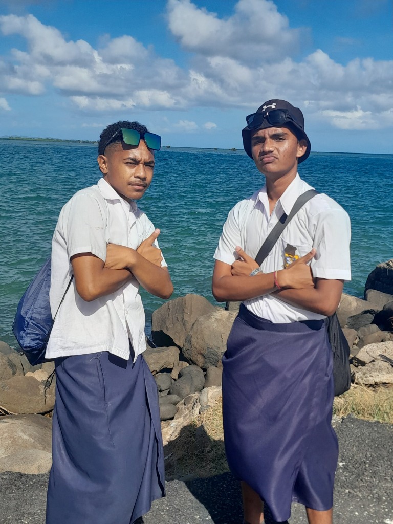 Aryan and friend by the ocean in traditional attire